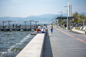 Serene seaside promenade with people fishing and strolling by the pier, set against coastal views. — Boosting Your Betting Co