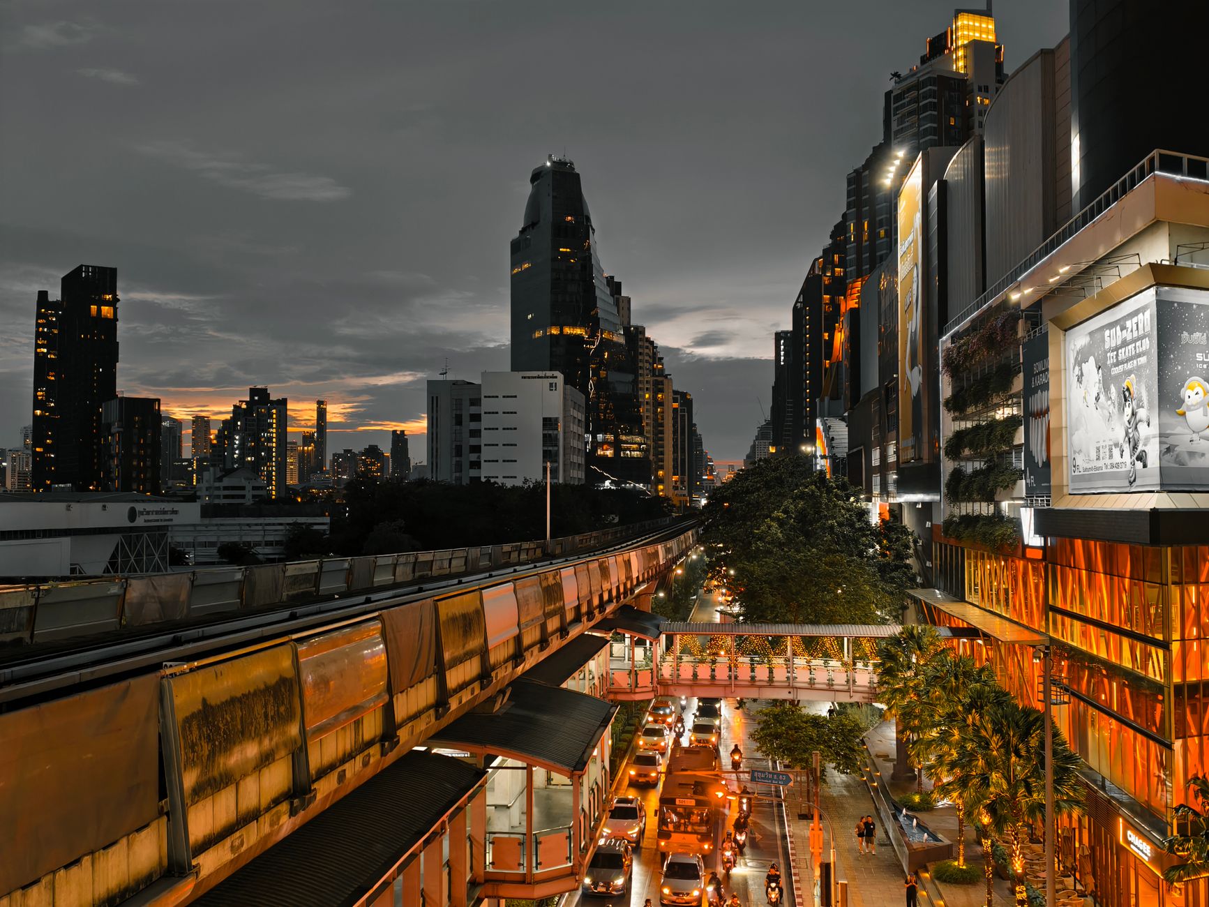Cityscape at twilight showing busy traffic, skyscrapers, and an elevated train line in an urban setting. — The Ultimate Guide